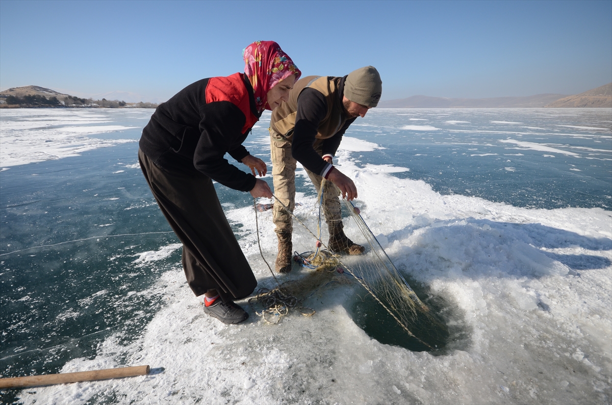 Eskimo usulü balık avlayan kadın, ekmeğini buzun altından çıkartıyor